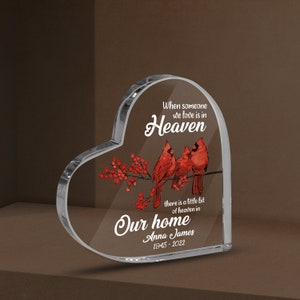 May include: A heart-shaped crystal memorial with a red cardinal bird design. The text reads "When someone we love is in Heaven, there is a little bit of heaven in our home."  The name "Anna James" and the dates "1945-2022" are also included.