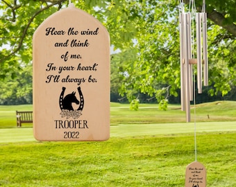 May include: Wooden wind chime with a horseshoe and floral design. The chime has a plaque with the text "Hear the wind and think of me. In your heart, I'll always be. TROOPER 2022".