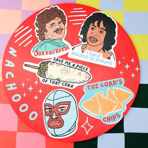 May include: A red round coaster with the words "NACHOO" written vertically in white. There are five stickers on the coaster: a corn on the cob with the text "Save me a piece of that corn", a wrestler wearing a blue and red mask, a man with brown hair and a mustache with the text "OoxxooXoXX", a man with long brown hair and the text "I only believe in science", and a group of yellow tortilla chips with the text "The Lord's Chips".