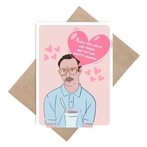 Könnte beinhalten: Eine rosa und weiße Grußkarte mit einer Cartoon-Illustration eines Mannes mit Brille und Schnurrbart. Der Mann hält eine Tasse und einen Löffel. Die Karte hat ein rosa Herz mit dem Text "Ich schätze, man könnte sagen, die Dinge werden ernst".
