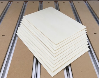 May include: A stack of white paper sheets on a wooden surface.