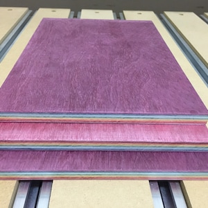 Pode incluir: Tr&ecirc;s pe&ccedil;as de folheado de madeira empilhadas umas sobre as outras. A pe&ccedil;a superior &eacute; de cor roxo escuro, a pe&ccedil;a do meio &eacute; de cor rosa claro e a pe&ccedil;a inferior &eacute; de cor azul claro.