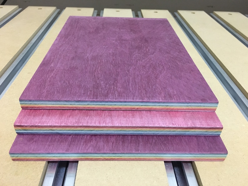 Pode incluir: Tr&ecirc;s pe&ccedil;as de folheado de madeira empilhadas umas sobre as outras. A pe&ccedil;a superior &eacute; de cor roxo escuro, a pe&ccedil;a do meio &eacute; de cor rosa claro e a pe&ccedil;a inferior &eacute; de cor azul claro.