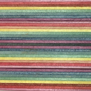 Pode incluir: Close-up de um painel de madeira multicolorido com listras alternadas de vermelho, amarelo, azul e verde.