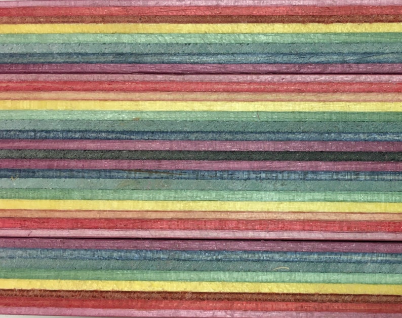 Pode incluir: Close-up de um painel de madeira multicolorido com listras alternadas de vermelho, amarelo, azul e verde.