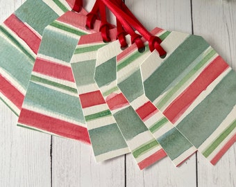 May include: Set of six watercolor gift tags with red and green stripes. The tags are tied with red ribbon.