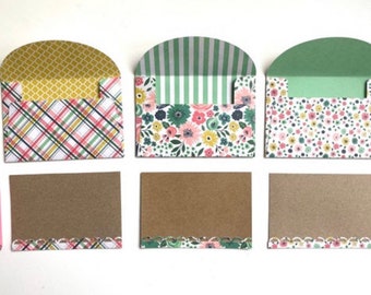 May include: Three decorative envelopes with different patterned designs, each with a brown card with a scalloped edge.