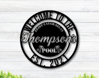 May include: Black metal welcome sign with the text "Welcome to the Thompson's Pool Est. 2021" and the words "Enjoy-Laugh-Relax" in a circle around the text.
