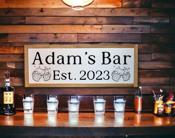 May include: A wooden sign with the text "Adam's Bar Est. 2023" and beer mugs. The sign is above a bar with glasses and bottles. The background is a wooden wall.