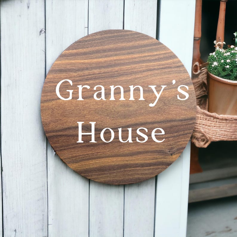 May include: A round wooden sign with the text "Granny's House" in white lettering.