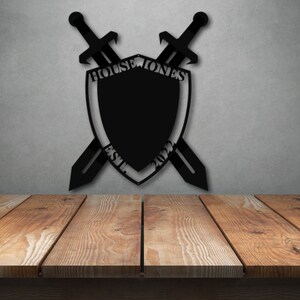 May include: Black metal shield with crossed swords, featuring the text "House Jones Est. 2022".