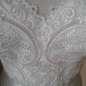 K&ouml;nnte beinhalten: Nahaufnahme eines wei&szlig;en Spitzenstoffs mit Paisley-Muster. Die Spitze ist zart und filigran, mit einem dezenten Glanz.
