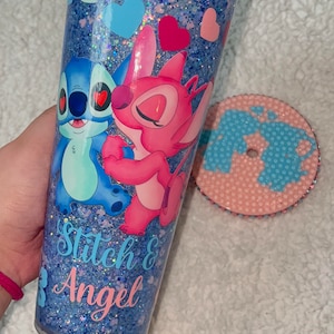 Może przedstawiać: Niebieski i r&oacute;żowy kubek z brokatem z obrazkiem Stitch i Angel z Lilo & Stitch. Kubek ma napis "Stitch & Angel".