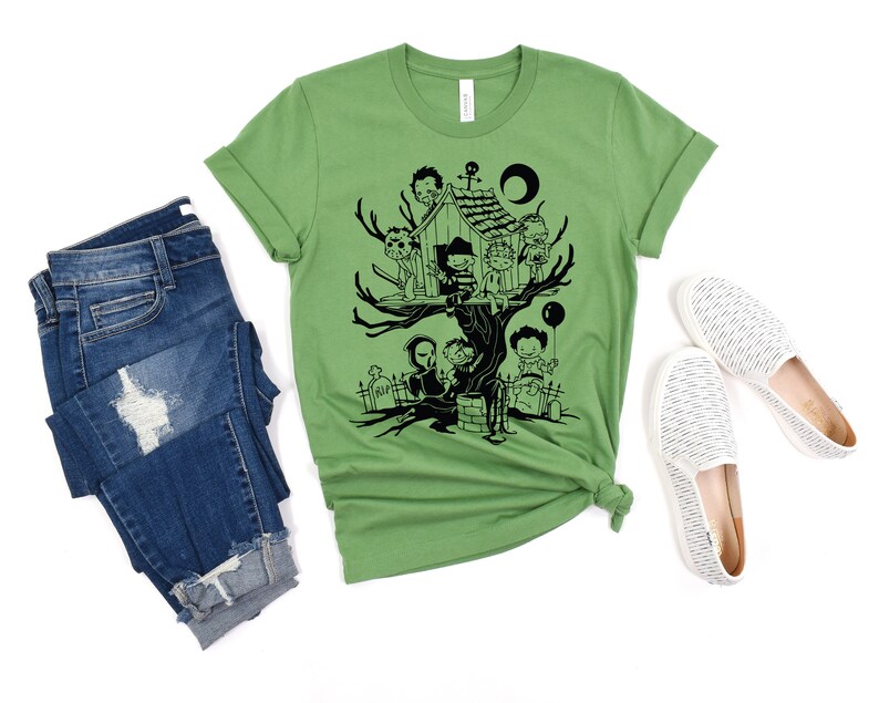 May include: A green t-shirt with a black graphic of horror movie characters in a treehouse. The characters include Freddy Krueger, Jason Voorhees, Michael Myers, and others.