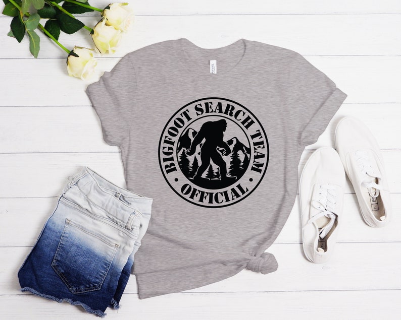 May include: A gray t-shirt with a black circle graphic that says "Bigfoot Search Team Official" with a silhouette of Bigfoot walking in the woods.