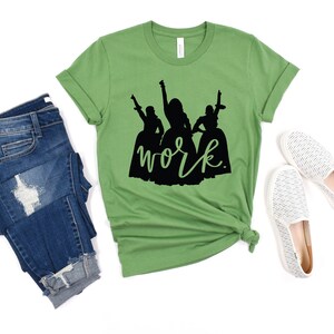 Peut inclure: T-shirt vert avec une silhouette noire de trois femmes et le texte "work" en dessous.