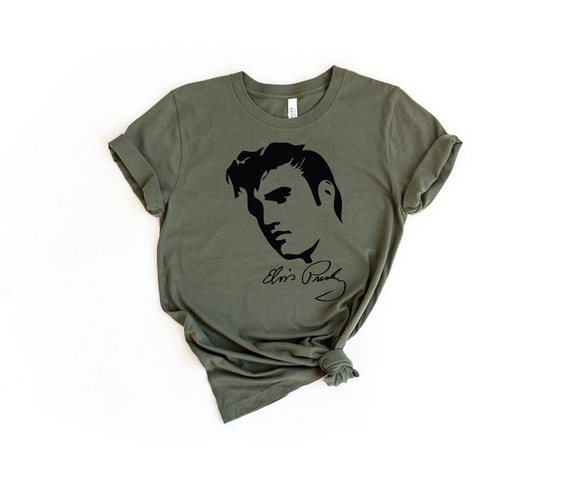 May include: A green t-shirt with a black silhouette of Elvis Presley's face and his signature.