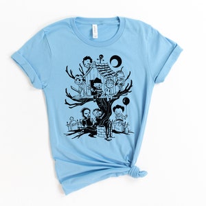 May include: Light blue t-shirt with a black graphic of horror movie characters in a treehouse. The characters include Freddy Krueger, Jason Voorhees, Michael Myers, and others.