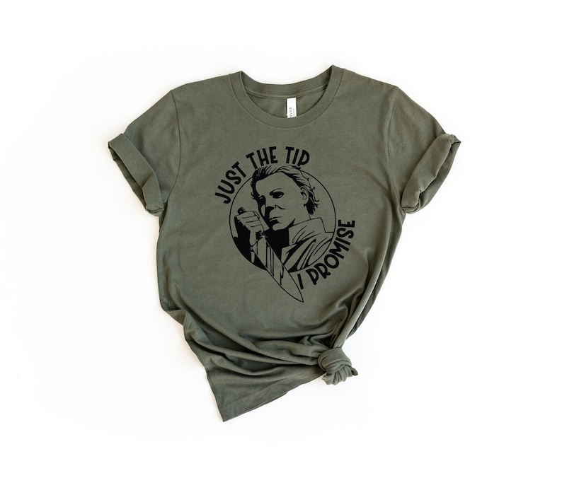 Pu&ograve; includere: Una maglietta verde con una grafica nera di Michael Myers del film Halloween. La grafica dice "Just the tip I promise".
