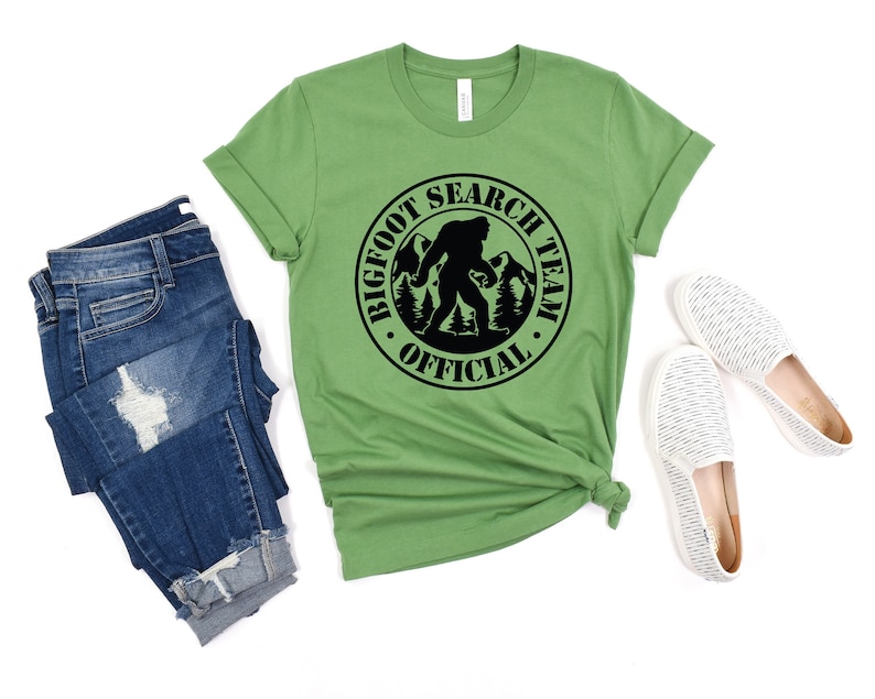 May include: Green t-shirt with a black circle graphic that says "Bigfoot Search Team Official" with a silhouette of Bigfoot walking in the woods.