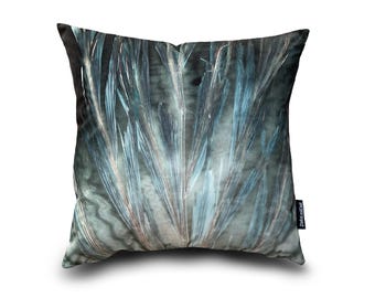 May include: A teal blue and grey throw pillow with a feather-like pattern. The pillow has a subtle sheen and a soft, plush texture.