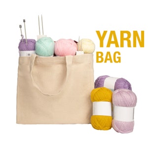 May include: A beige canvas tote bag filled with colorful yarn balls and knitting needles. The bag has a YARN BAG label on the front.