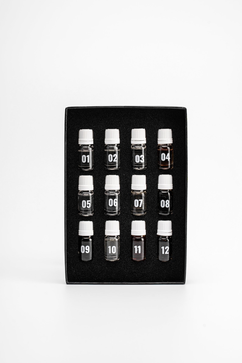 May include: A black box with 12 small glass bottles with white caps. Each bottle is labeled with a number from 01 to 12.