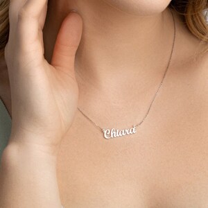 May include: A silver necklace with the name "Chiara" spelled out in cursive script.