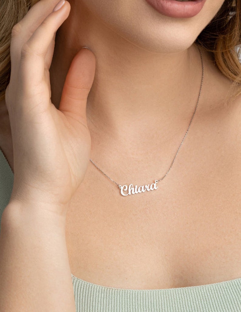 May include: A silver necklace with the name "Chiara" spelled out in cursive script.