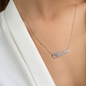 May include: A silver necklace with the name "Chiara" spelled out in cursive script.