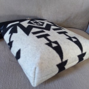 May include: Black and white patterned pillow with a geometric design. The pillow is made of a soft, fuzzy material and has a white border.