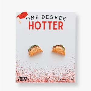 May include: A pair of nickel-free taco earrings with the text "ONE DEGREE HOTTER" on a white card with a red graduation cap.