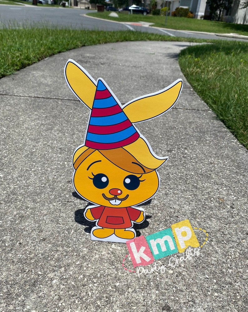 Puede incluir: Un personaje de dibujos animados amarillo con un gorro de fiesta rojo y azul, que lleva un vestido rojo con un cuello amarillo y un delantal blanco. El personaje tiene una nariz amarilla, ojos marrones y un peque&ntilde;o bigote. El personaje est&aacute; de pie en una acera gris. El texto "kmp Party Crafts" es visible en la esquina inferior derecha de la imagen.