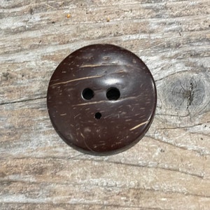 Smooth polished convex side of the diz, showing natural pattern of coconut shell.
