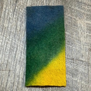 May include: A small rectangular piece of fabric with a gradient of blue, green, and yellow.