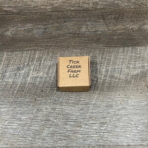 Packaging box folded and closed with Tick Creek Farm LLC printed on the top.