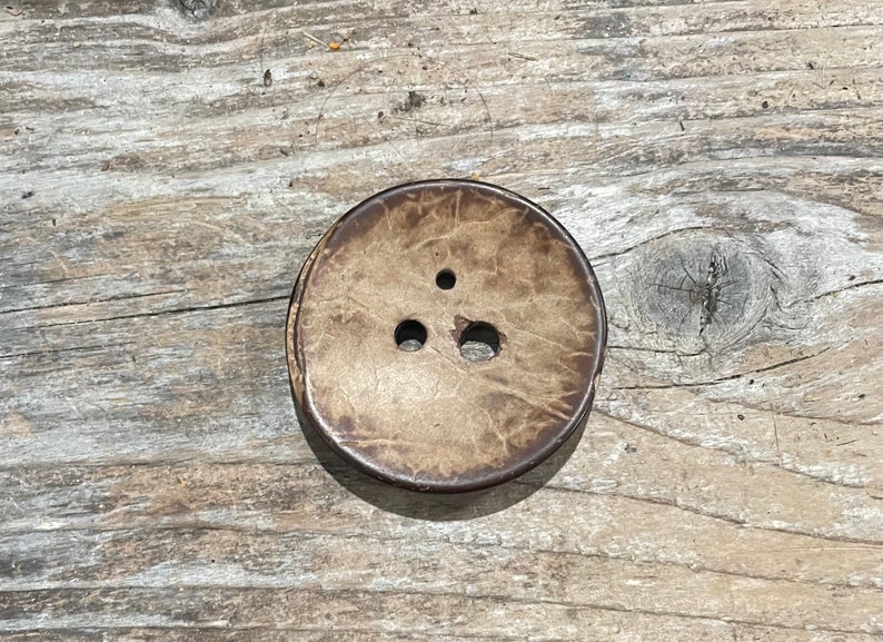 Unfinished concave side of diz, showing natural coconut shell pattern.