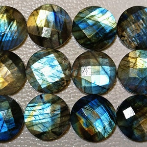 Op de afbeelding: Twaalf gefacetteerde, ronde labradoriet edelstenen. De stenen vertonen een mix van kleuren, waaronder blauw, groen en goud, met een glinsterend, iriserend effect. Elke steen heeft een diameter van ongeveer 1,9 cm.