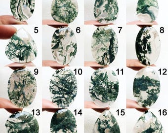 May include: A selection of sixteen moss agate gemstones in diverse shapes, such as oval, teardrop, and round. Each stone displays unique patterns of green, moss-like inclusions within a translucent or opaque base, highlighting natural variations. The gemstones are held up by fingers.