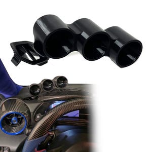 May include: A black triple gauge pod mount featuring three circular openings for automotive instruments, designed with an integrated side vent attachment. The component is shown both as a standalone unit and installed on a vehicle dashboard.