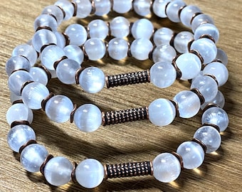 May include: Three white moonstone beaded bracelets with copper wire accents. Each bracelet has a copper bar clasp.