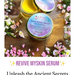 May include: A small jar of yellow serum with a gold lid. The jar is labeled "Revive MySkin Serum" and features a logo with a crystal and the text "Crystal Health Goddess". The jar is surrounded by pink flowers on a wooden surface. The text "Revive MySkin Serum" is also written in large letters at the top of the image, with stars on either side. The text "Unleash the Ancient Secrets to a Youthful Glow!" is written below the product name. The website address "www.CrystalHealthGoddess.com" is at the bottom of the image.