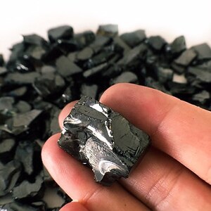 May include: A single, irregularly shaped piece of black hematite crystal. The crystal has a metallic sheen and is rough and jagged.