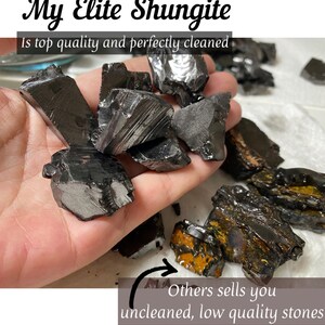 May include: Close-up of a hand holding a pile of black shungite stones. The stones are smooth and polished. The text "My Elite Shungite" and "Is top quality and perfectly cleaned" is visible at the top of the image. The text "Others sells you uncleaned, low quality stones" is visible at the bottom of the image with an arrow pointing to a pile of rough, unpolished shungite stones.