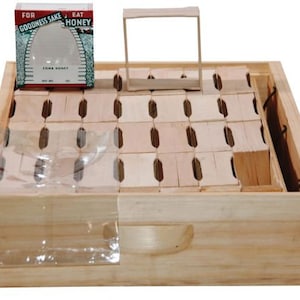 May include: A wooden beehive box with a removable frame and a clear plastic sheet. The box has a label that reads "For Goodness Sake Eat Honey Comb Honey".