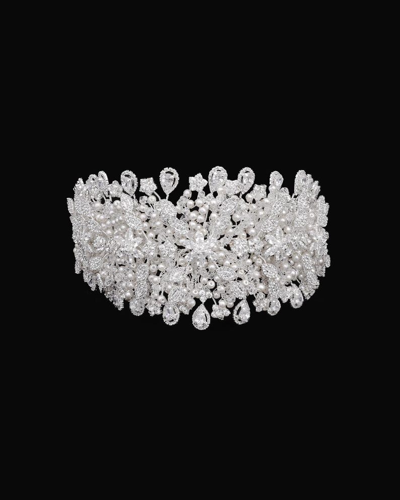 May include: A silver and white bridal headband with pearl and rhinestone embellishments