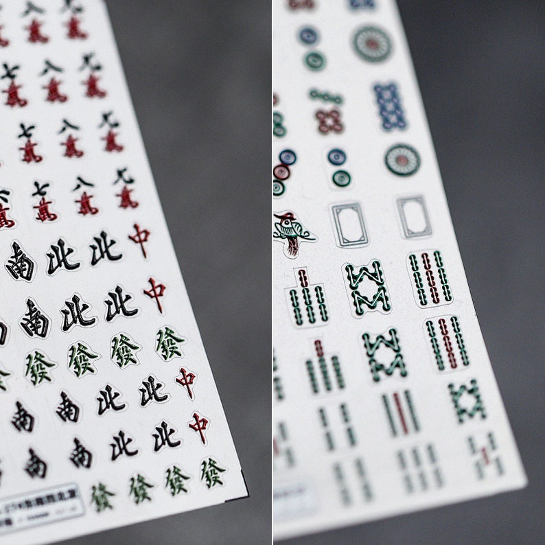 May include: Two sheets of white stickers with black, red, and green Chinese characters and symbols. The stickers are for a mahjong game.