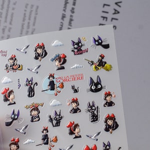 May include: A sheet of stickers featuring characters from the animated film Kiki's Delivery Service. The stickers feature Kiki, Jiji the black cat, and other characters from the film. The stickers are printed on clear vinyl and are perfect for decorating laptops, water bottles, and other surfaces.