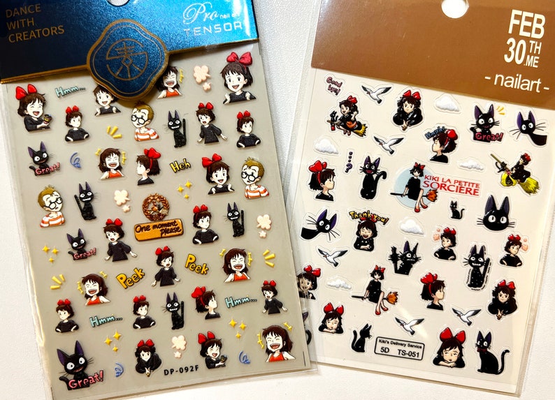 May include: Two sheets of nail art stickers featuring characters from the animated film Kiki's Delivery Service. The stickers are on a white background and feature Kiki, Jiji the black cat, and other characters from the film. The text on the stickers reads "Kiki La Petite Sorciere" and "Great!" The stickers are packaged in clear plastic bags with the text "Dance with Creators" and "Pro Tensor" on the top of the bags.