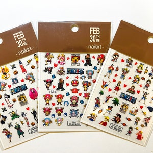 May include: Three sheets of nail art stickers featuring characters from the anime One Piece. The stickers are on a brown background with the text "FEB 30TH - nailart -" printed on each sheet. The stickers feature a variety of characters, including Luffy, Zoro, and Sanji.